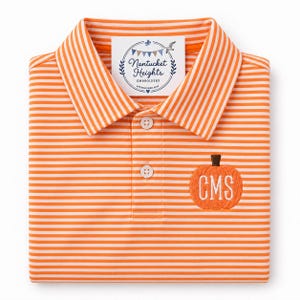 May include: An orange and white striped polo shirt featuring a collar and a three-button placket. An embroidered orange pumpkin with the white monogram letters CMS is on the chest. A white tag reads Nantucket Heights Embroidery Established 2019.