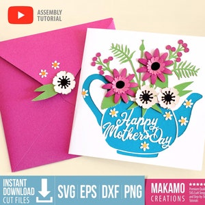 Peut inclure: Une théière bleue avec un bouquet de fleurs roses et blanches. La théière a un fond blanc avec le texte "Happy Mother's Day" en bleu. La carte est parfaite pour un cadeau de fête des mères.