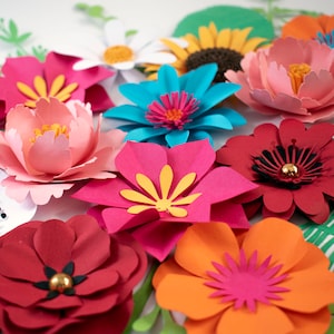 May include: A collection of colorful paper flowers in various shapes and sizes. The flowers are made from different colors of paper, including pink, red, orange, yellow, blue, and white. The flowers are arranged in a cluster on a white background. The text "MAKAMO CREATIONS" is visible in the lower right corner of the image.