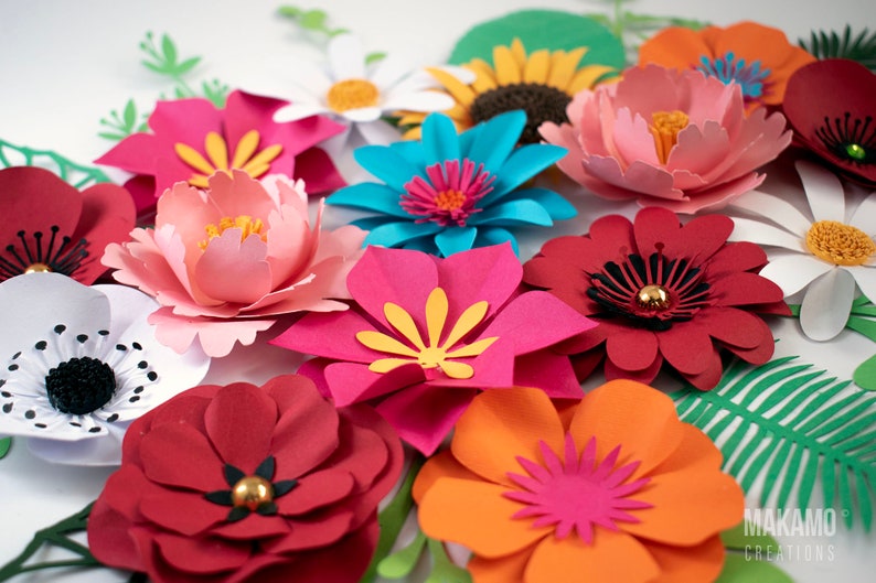 May include: A collection of colorful paper flowers in various shapes and sizes. The flowers are made from different colors of paper, including pink, red, orange, yellow, blue, and white. The flowers are arranged in a cluster on a white background. The text "MAKAMO CREATIONS" is visible in the lower right corner of the image.
