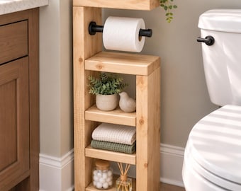 May include: A natural pine wood bathroom storage unit featuring a toilet paper holder with a black metal rod, three open shelves for organization, and the text Natural Pine. The shelves hold a small potted plant, a bird figurine, folded towels, a jar of cotton balls, and a reed diffuser.