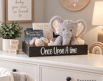May include: A dark brown wooden rectangular tray featuring the white text Once Upon A Time on the front. The tray contains a plush gray elephant, a small crocheted rabbit, and two children's books titled Good Night, Little One and I Love You.