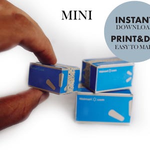 Può includere: Scatole di spedizione in miniatura in cartone blu con il logo Walmart.com e dettagli in nastro bianco. Il testo MINI, INSTANT DOWNLOAD, PRINT&DIY e EASY TO MAKE è visibile. Queste piccole scatole di carta sono da assemblare ed esporre.