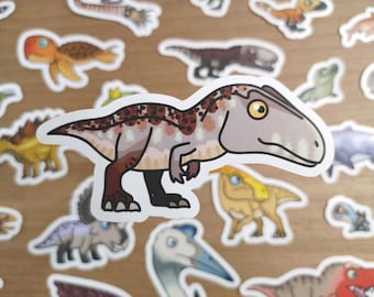 May include: A sticker featuring a cartoon dinosaur with a light gray head, brown and white body, and black feet. The sticker is surrounded by other dinosaur stickers on a wooden surface. The dinosaur has a friendly expression.