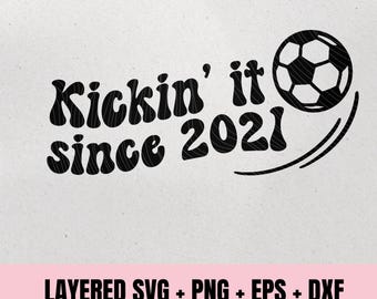 May include: Black graphic with the text "Kickin' it since 2021" and a soccer ball. The design includes curved lines suggesting motion. Below, text indicates the file types: SVG, PNG, EPS, and DXF, for instant download.