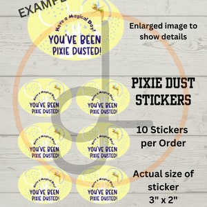 May include: Ten yellow oval stickers with a Tinkerbell design. Each sticker features a fairy with pixie dust, a castle, and the text "Have a Magical Day! You've Been Pixie Dusted!" The stickers are 3 inches by 2 inches.