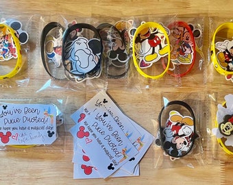 May include: A set of eight yellow silicone bracelets with various Disney character stickers. Each bracelet is packaged in a clear plastic bag with a small card that reads "You've Been Pixie Duoted! We hope you have a magical day!"