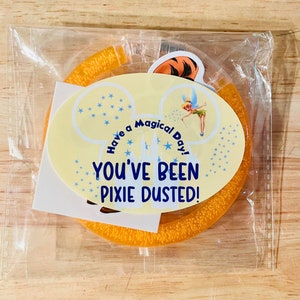 May include: A yellow Mickey Mouse-shaped headband with glitter and the text "Have a Magical Day! You've Been Pixie Dusted!"