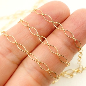May include: Three gold chains with oval links. The chains are arranged in a row, with the largest chain at the top and the smallest chain at the bottom.