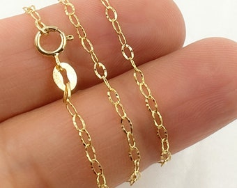 Puede incluir: Un collar de cadena de oro con un delicado diseño de eslabones ovalados texturizados. La cadena se muestra en una mano, con el cierre visible.