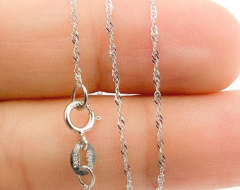 May include: A thin, silver-colored twisted chain necklace featuring a round spring ring clasp. The metal tag near the clasp is clearly stamped with the text 925 and ITALY, indicating the material composition and origin of this delicate jewelry piece.