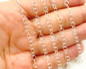 Puede incluir: Cadena de plata con múltiples hebras de pequeños eslabones redondos. La cadena se muestra en una mano, con los eslabones extendiéndose desde la mano.