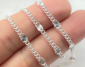 May include: Three silver chains with a textured, starburst design on each link. The chains are arranged in a row, with the top chain being the longest and the bottom chain being the shortest.