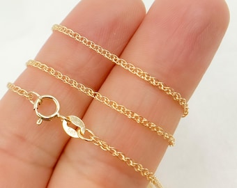 May include: Close-up of a delicate gold chain necklace. The chain features a fine, textured design with a small clasp. The necklace is a warm gold color, and the clasp is marked with "585".