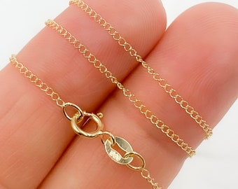 Puede incluir: Un delicado collar de cadena de color dorado con un pequeño cierre. La cadena está hecha de pequeños eslabones interconectados, creando una apariencia fina y texturizada. El collar se sostiene sobre un fondo claro, resaltando su color y diseño.