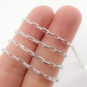 May include: Silver chain with a box link design. The chain is shown in multiple lengths.