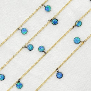 May include: A gold chain necklace with multiple strands and blue opal gemstone pendants.