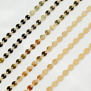 May include: Four gold chains with round, flat links. The chains are arranged in a staggered pattern on a white background.