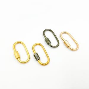 May include: Three oval-shaped metal keychains in gold, silver, and rose gold. Each keychain has a small, cylindrical bar in the center.