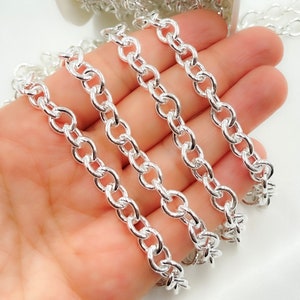 May include: Silver chain with a curb link design. The chain is shown in multiple strands, highlighting its thickness and shine.