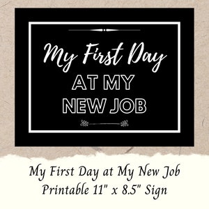 Op de afbeelding: Een zwart-wit bord met de tekst "My First Day At My New Job". Het bord is wit omlijst en heeft decoratieve elementen. De onderkant van het bord luidt "My First Day at My New Job Printable 28 cm x 22 cm Sign".