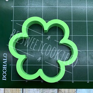 Pu&ograve; includere: Tagliapasta verde brillante a forma di quadrifoglio. Il tagliapasta &egrave; realizzato in plastica e ha un bordo liscio e arrotondato. Il testo "BEES SWEET COOKIES" &egrave; scritto sull'immagine.