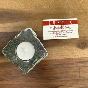 May include: A green and purple stone candle holder with a white tea light candle inside. The candle holder is on a wooden surface. The business card for Rustic & Rebellious is visible in the background.