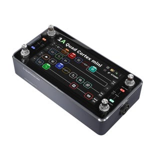 May include: A dark gray 1A Quad Cortex mini guitar effects pedal with a black screen displaying colorful icons and text. It has four silver knobs and a black input jack. The pedal is designed for guitarists.