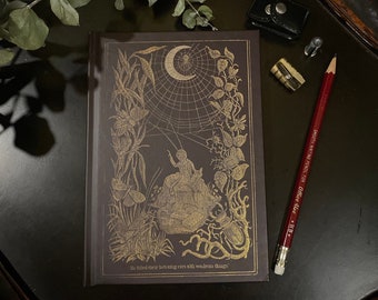 May include: A dark brown journal with a gold embossed design featuring a spider web, a crescent moon, and a spider. The text "He filled their listening ears with wondrous things" is printed on the bottom of the journal.