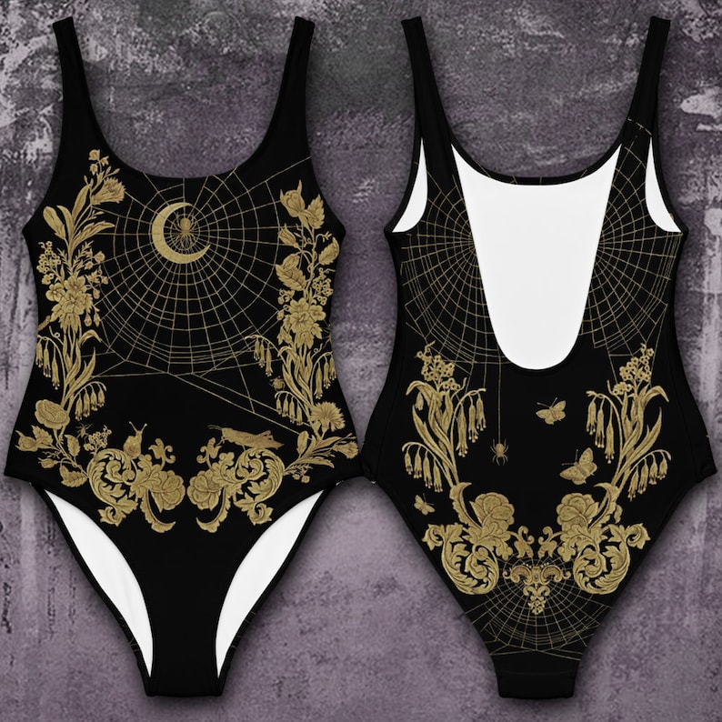 May include: Black one-piece swimsuit with a gold spiderweb design, featuring a crescent moon, spider, and floral details.