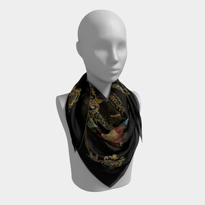 May include: A black silk scarf with a gold and floral pattern. The scarf is folded and draped around a mannequin's neck.