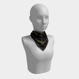May include: A black silk scarf with a gold and red design. The scarf has a paisley pattern and a heart shape in the center.