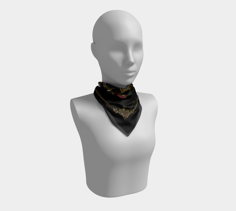 May include: A black silk scarf with a gold and red design. The scarf has a paisley pattern and a heart shape in the center.