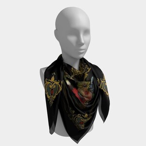 May include: A black silk scarf with a gold and red floral design. The scarf is worn by a mannequin.
