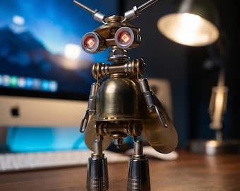 May include: A metallic insect-like sculpture constructed from brass and steel components. It features two glowing red circular eyes, antenna-like protrusions on the head, a rounded brass body, two large wing-like plates, and two cylindrical legs.