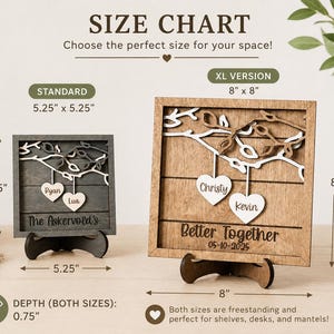 K&ouml;nnte beinhalten: Zwei quadratische Holzschilder mit Ast- und Herzmotiv auf St&auml;ndern. Das Standardschild misst 13,34 cm x 13,34 cm, die XL-Version 20,32 cm x 20,32 cm. Beide haben eine Tiefe von 1,91 cm und sind mit verschiedenen Texten und Namen versehen.