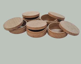 Könnte beinhalten: Sechs runde Holzkisten mit Deckeln. Die Kisten sind aus hellbraunem Holz und haben eine natürliche Oberfläche.