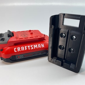 May include: A red and black Craftsman V20 lithium-ion battery with a black plastic battery holder.