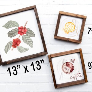 Puede incluir: Tres ilustraciones enmarcadas con tem&aacute;tica de caf&eacute;. El marco m&aacute;s grande mide 13 pulgadas por 13 pulgadas y presenta una pintura de acuarela de una planta de caf&eacute; con bayas rojas. El marco del medio mide 7 pulgadas por 7 pulgadas y muestra un latte con arte latte. El marco m&aacute;s peque&ntilde;o mide 9 pulgadas por 9 pulgadas y presenta una taza de caf&eacute; con el texto "but first, coffee".