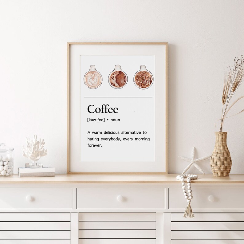 May include: A printable wall art design featuring a definition of coffee with three illustrations of coffee cups. The text reads "Coffee [kaw-fee] noun A warm delicious alternative to hating everybody, every morning forever."