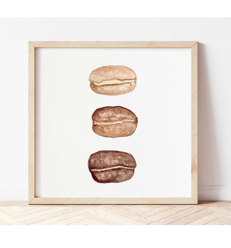 May include: Three watercolour illustrations of coffee beans, each in a different stage of roasting. The top bean is light brown, the middle bean is medium brown, and the bottom bean is dark brown.