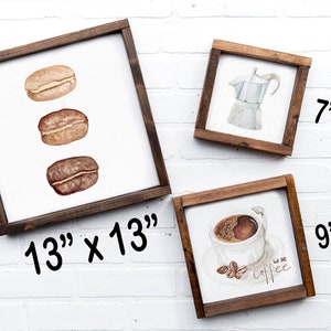 May include: Three framed wood signs with coffee-themed illustrations. The largest sign is 13 inches by 13 inches and features three coffee beans. The middle sign is 7 inches by 7 inches and features a silver coffee pot. The smallest sign is 9 inches by 9 inches and features a cup of coffee with the text "but first, coffee".