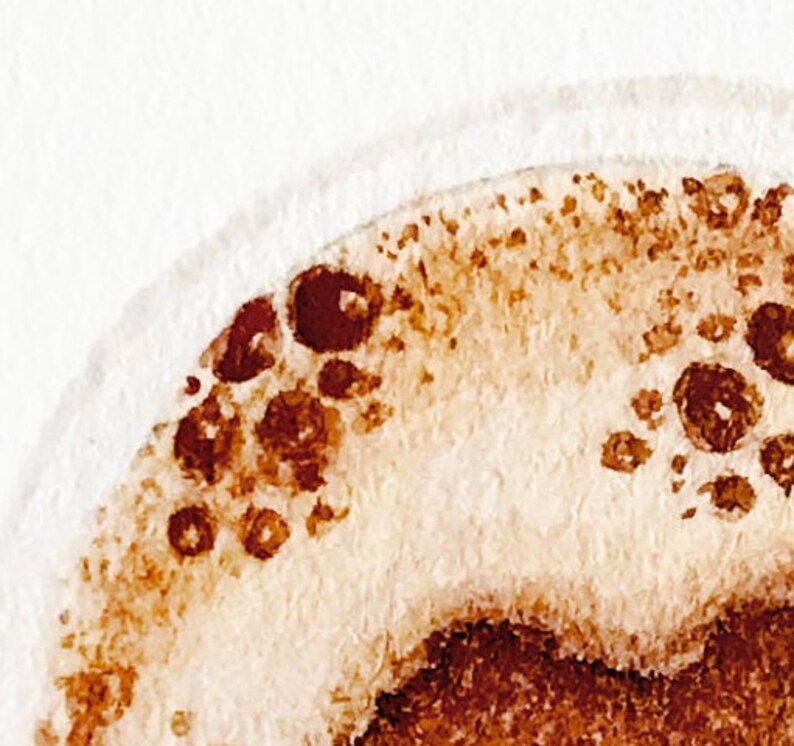 May include: Close-up of a watercolor painting of a coffee cup with brown and white paint. The coffee cup is filled with coffee and has a foam layer on top.