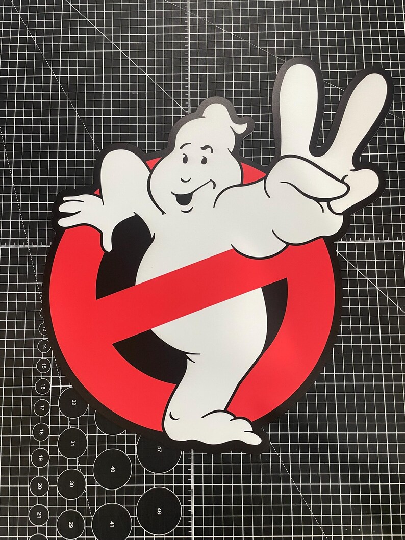 May include: A white ghost character with a smiling expression making a peace sign with one hand, positioned in front of a red circular prohibition symbol with a diagonal slash, rendered in a flat graphic style with bold black outlines.