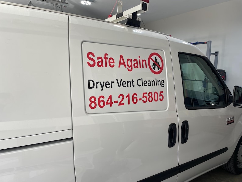 May include: A white commercial van featuring a rectangular sign on the side panel. The sign displays the red and black text Safe Again, the words Dryer Vent Cleaning in black, a red no-fire symbol, and the phone number 864-216-5805 in red.