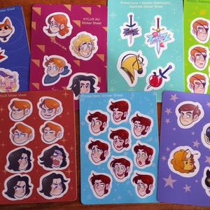 May include: Nine sticker sheets featuring various illustrations. The sheets are printed on white cardstock and have a glossy finish. The illustrations include a character with a sword, a character with a cup of tea, a character with a cat, a character with a horse, a character with an apple, a character with a sword, a character with a cat, a character with a dog, and a character with a cat. The sticker sheets are all different colors and have different designs.