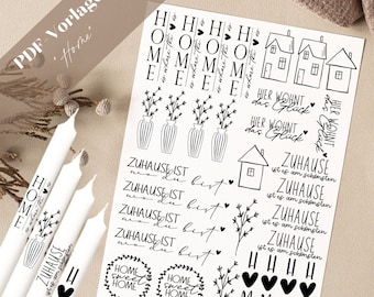 Op de afbeelding: Een vel met zwart-witte printbare stickers met verschillende ontwerpen, waaronder huizen, bloemen, harten en tekst. De tekst omvat "Home", "Home Sweet Home", "Zuhause ist", "Hier wohnt das Glück" en "HHHH MMMMM EEEEE".