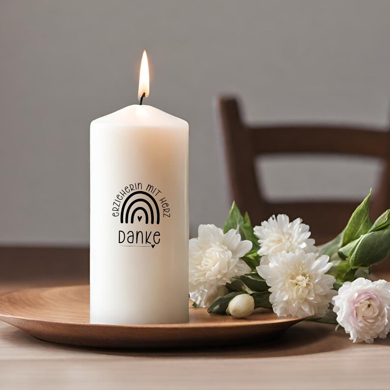 Puede incluir: Vela blanca en forma de pilar con un dise&ntilde;o en blanco y negro que dice "Erzieherin mit Herz Danke" con un arco&iacute;ris y un coraz&oacute;n.