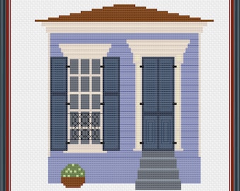 May include: A cross-stitch pattern of a blue house with white trim, a brown roof, and a small potted plant in front. The house has two windows with blue shutters and a door with blue shutters.