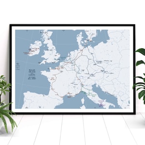 May include: Framed map print of Europe with travel routes highlighted in various colors. Text includes "Meagan and Rob Europe Six Years Well Spent" and location names like "West Belad" and "Italian Coast". The map is set against a light blue background.